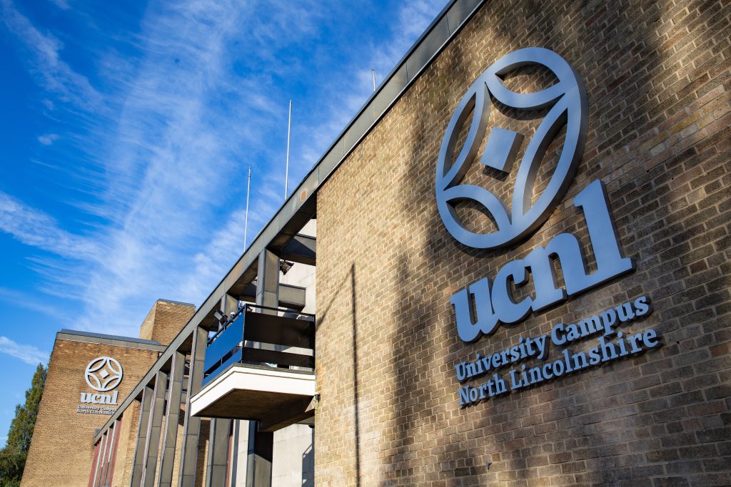 Image of the ucnl building from outside showing the ucnl logo on the side of the wall.